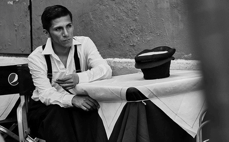 A determined young actor dressed nicely sitting on a movie set imagining his future