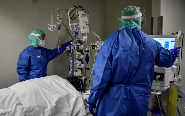 A woman hospitalized in a very bad state being treated by doctors trying to save her life